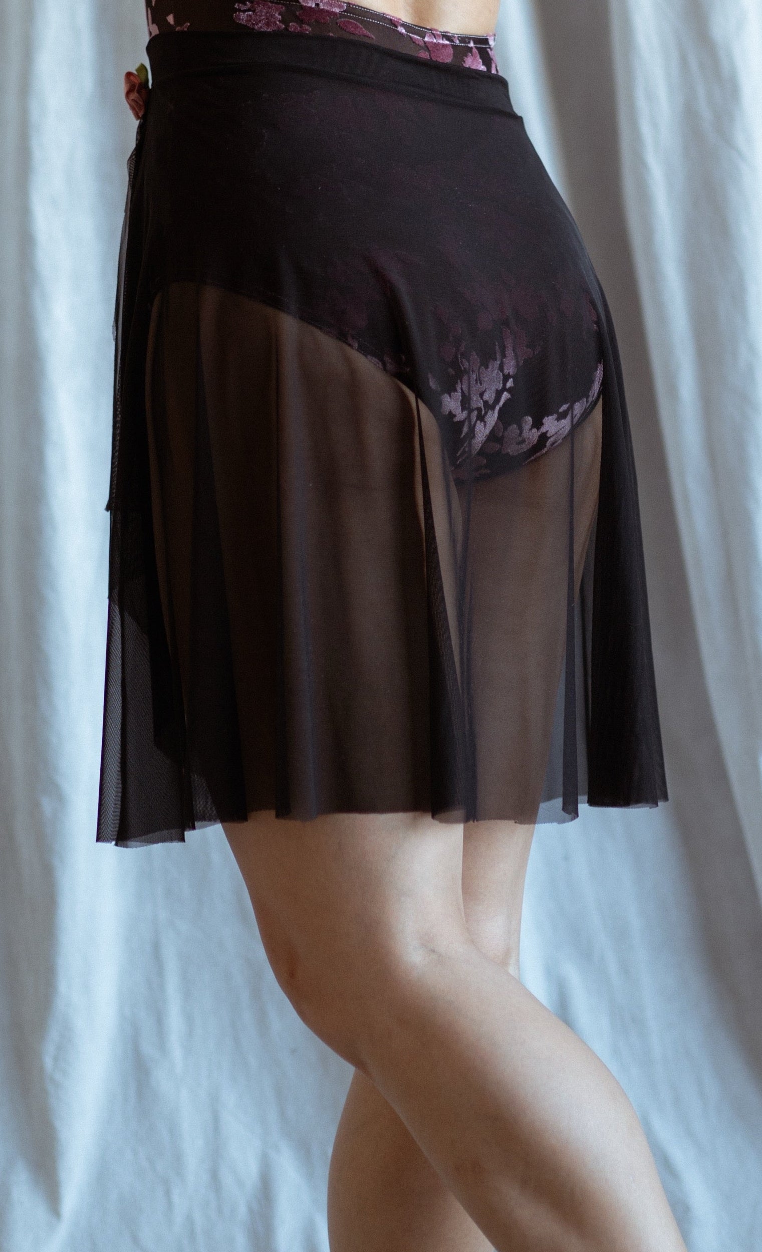 Black skirt with sheer overlay on a white background